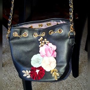 Smqll black shoulder bag with flower detail and chain strap